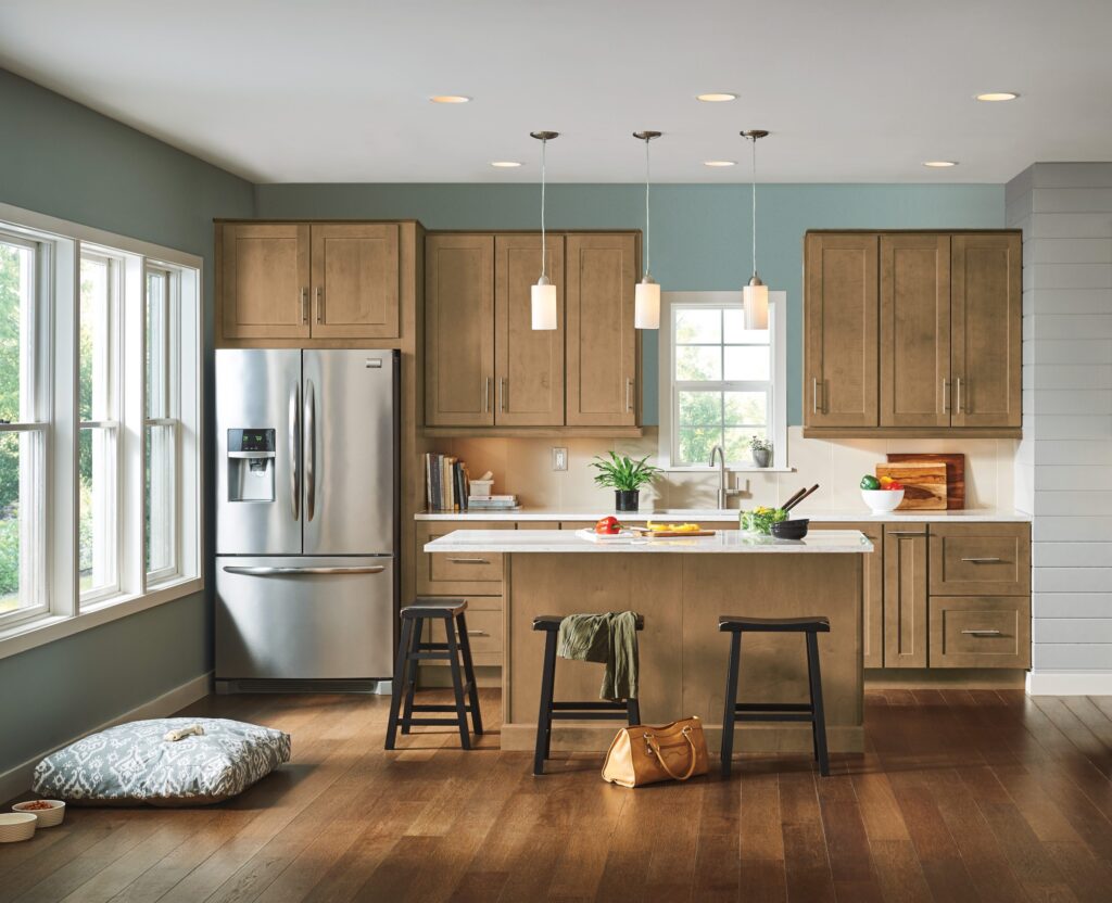 picture of kitchen with brown cabinets and island, teal walls, and personal items throughout