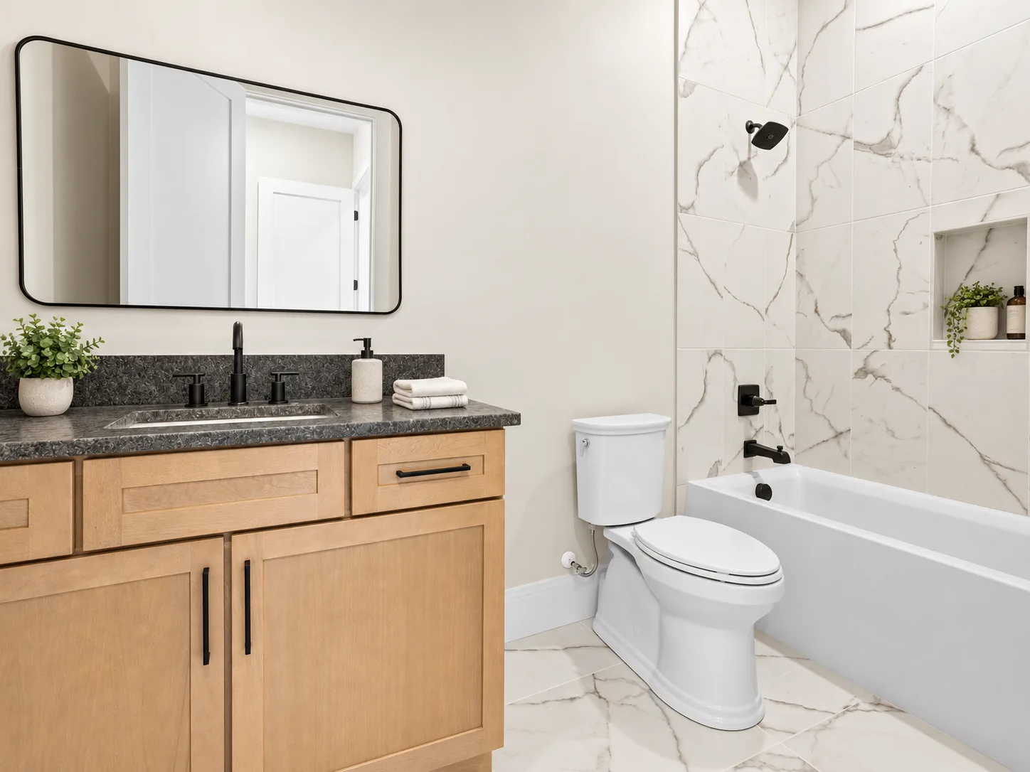 Guest bath with stained vanity and black-framed mirror
