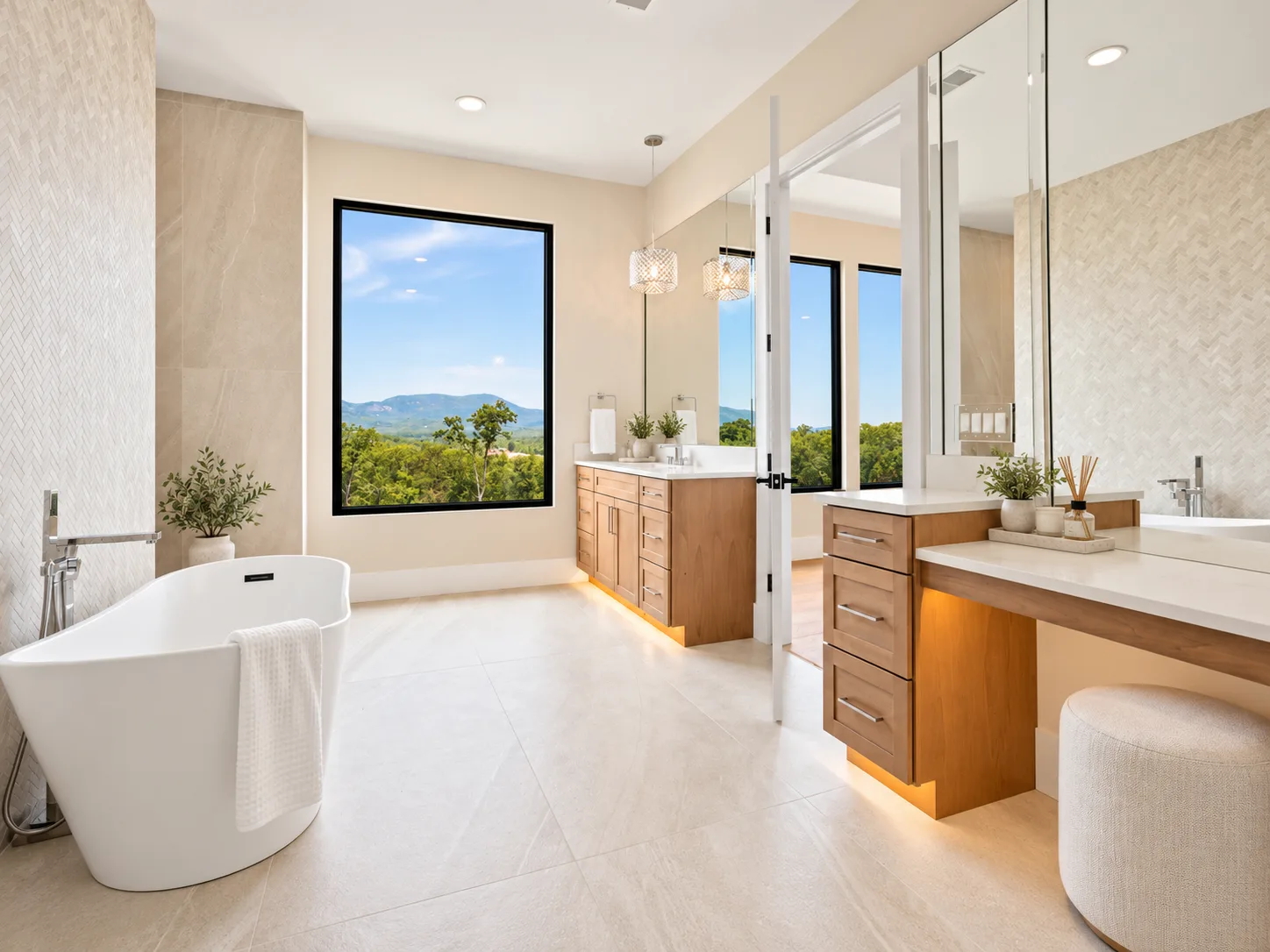 Master bath with stained vanities, freestanding tub, and mountain view