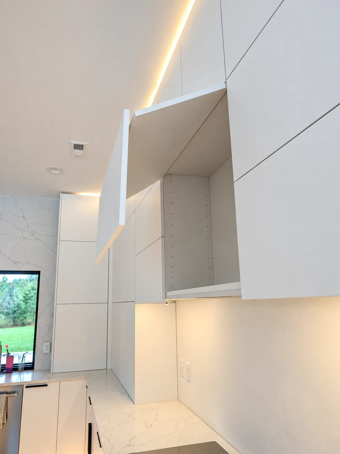 White slab cabinetry with lift-up door and integrated lighting