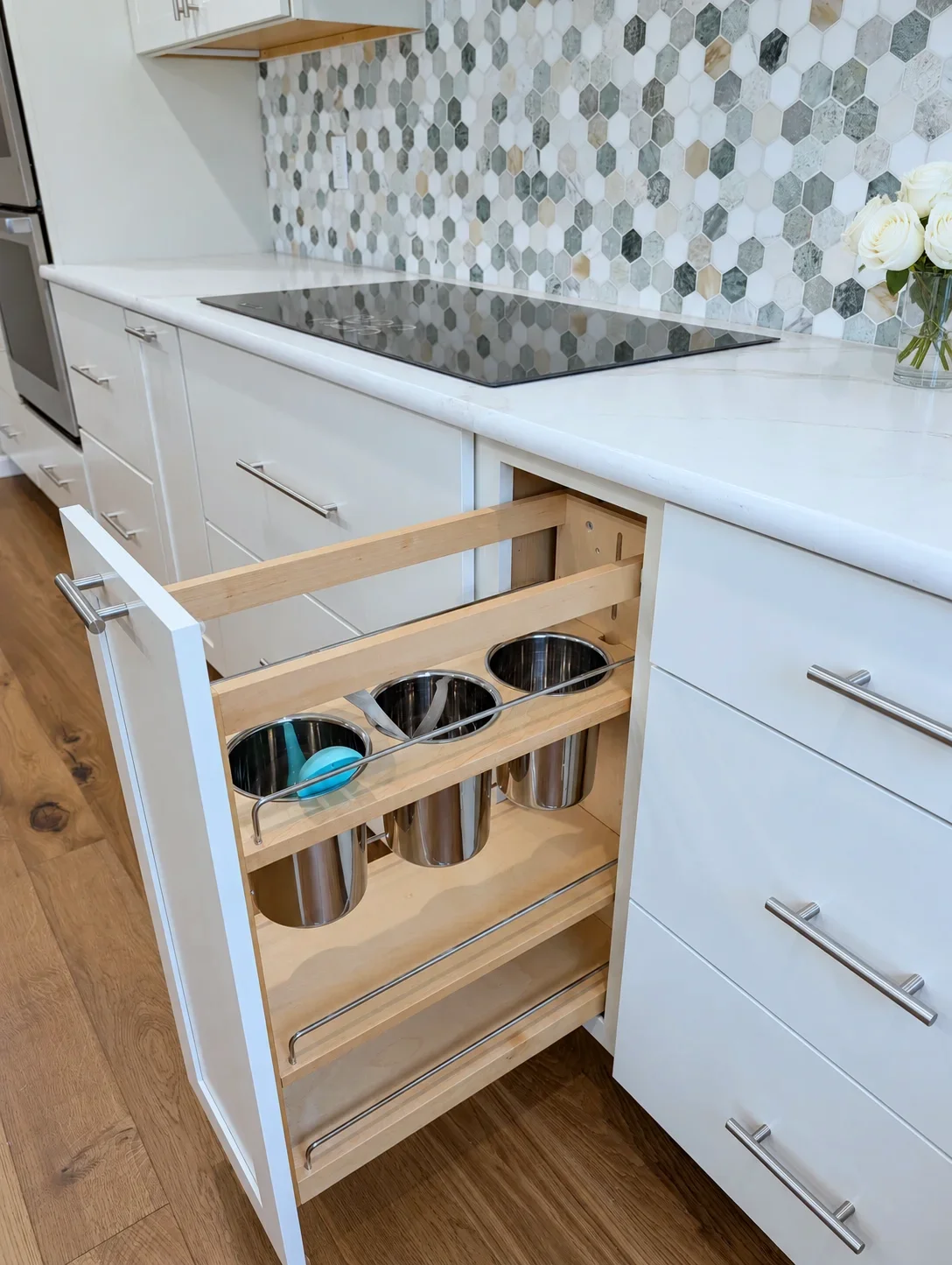Pull-out utensil organizer beside the cooktop in a Blond Maker Series kitchen, Oregon