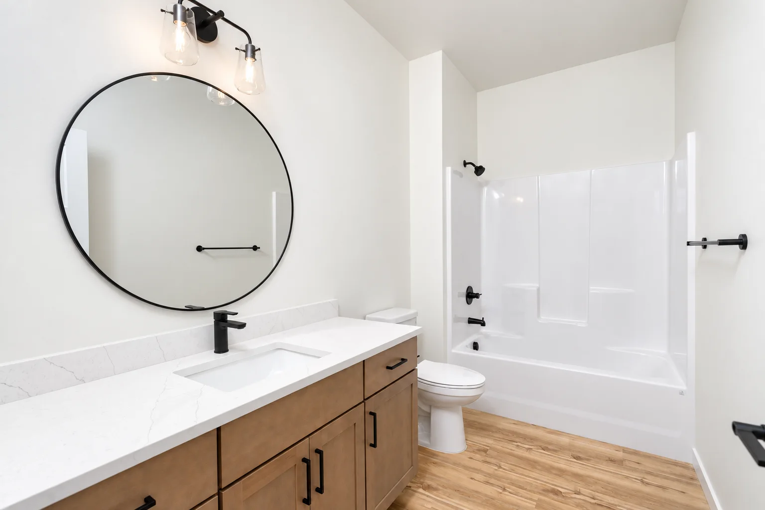 Hall bath with Element on Maple vanity, round mirror and black fixtures, northwest Washington spec
