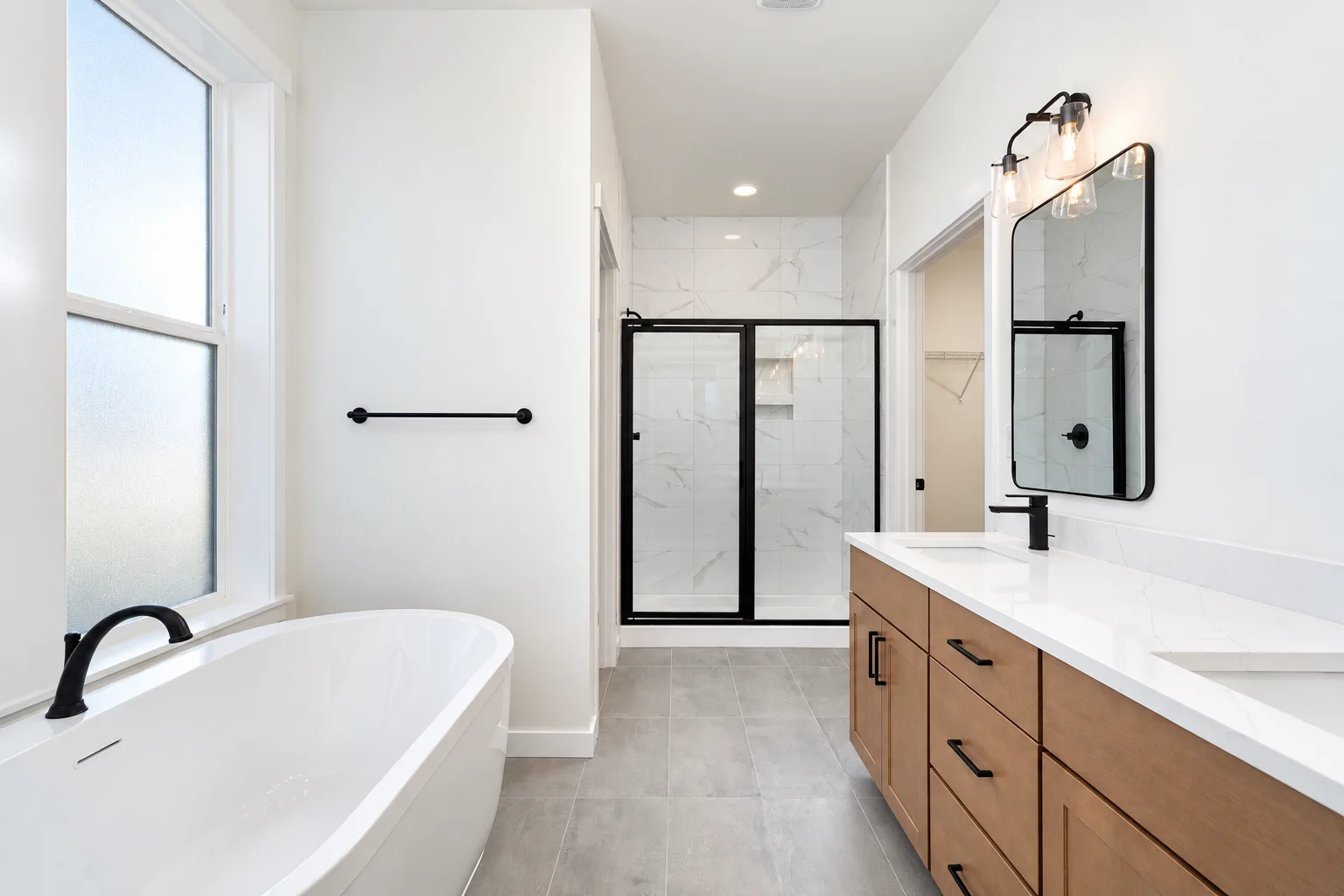 Primary bath with Element on Maple vanity, freestanding tub and black framed shower, northwest Washington