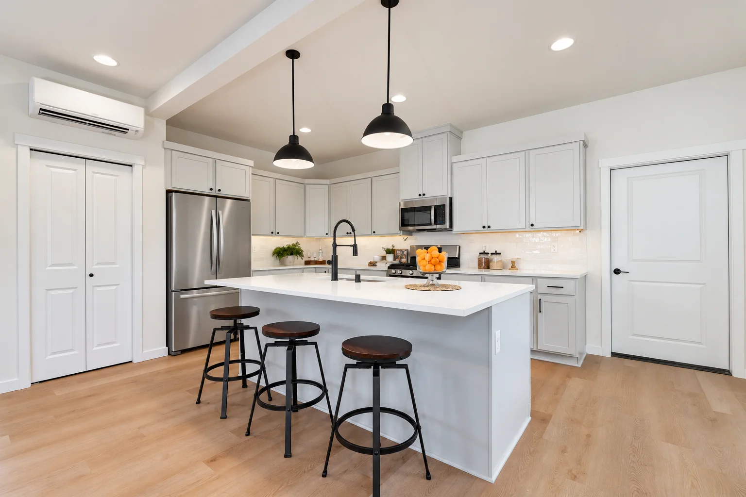 Kitchen island with seating and black dome pendants, Cloud cabinets, northwest Washington spec home
