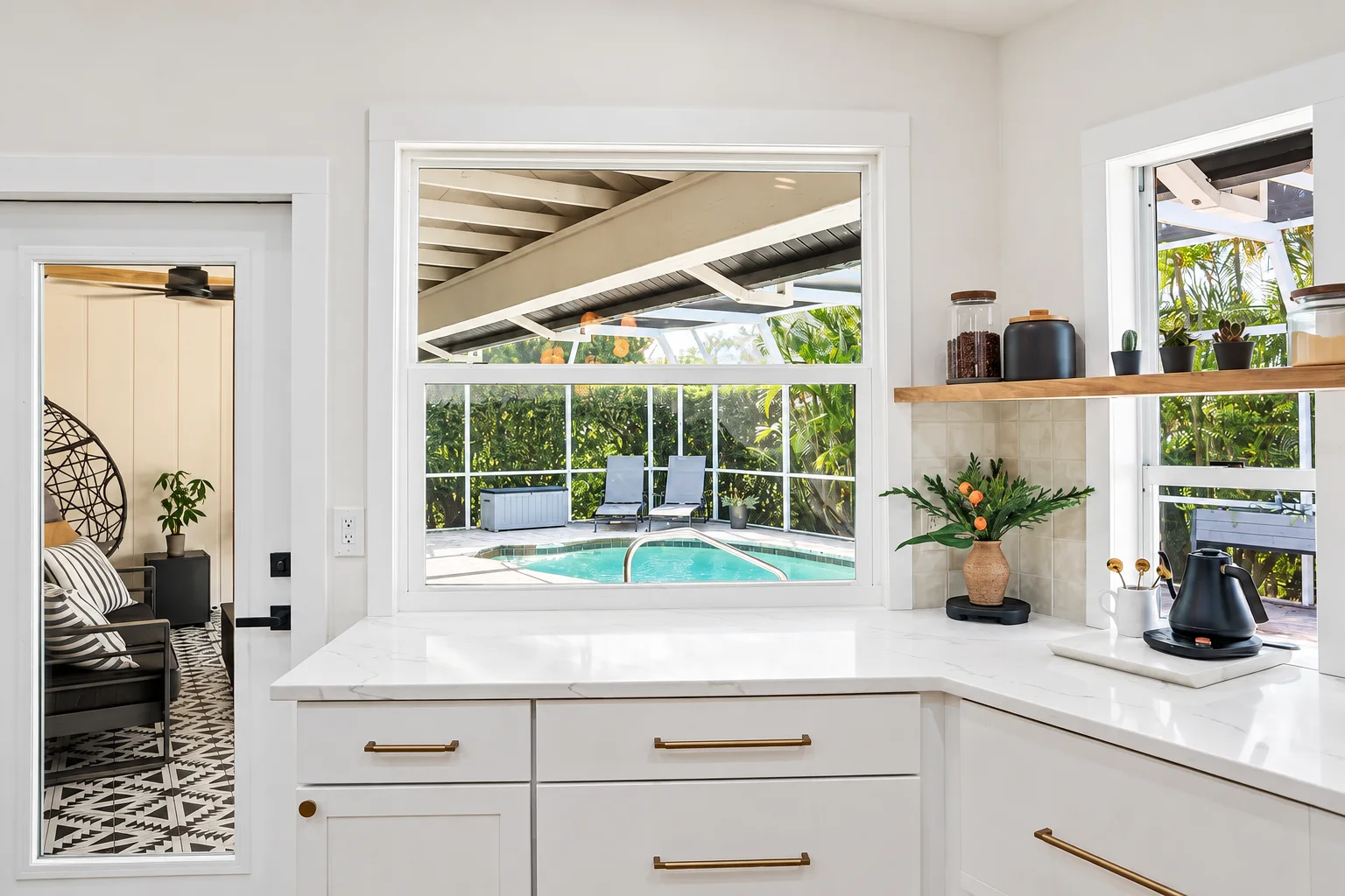 Corner kitchen window with pool view, white cabinets and brass hardware, Sarasota Florida remodel