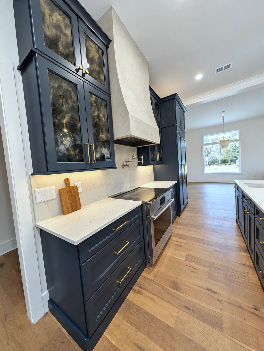 Range wall with white hood and Custom Blue glass front uppers, South Carolina builders personal home